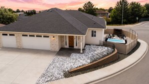 Une maison d’habitation avec un garage, un patio couvert et une piscine.