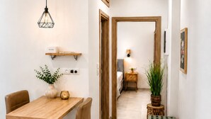 Ein modernes Interieur mit Essbereich, einer Couch und einem Flur, der zum Schlafzimmer führt.