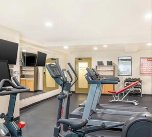 Ein Fitnessstudio mit stationären Fahrrädern, Laufbändern und Kurzhanteln.