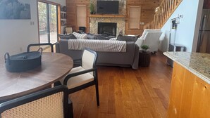 Una cocina moderna con comedor, piso de madera y chimenea.