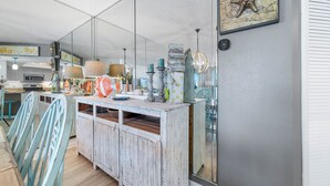 Een keuken met een houten kookeiland, stoelen en een grote spiegel.