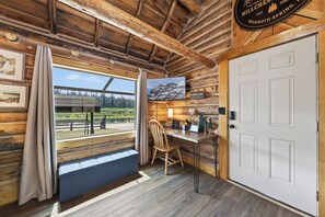 A wooden interior with a desk, chair, and a view of a lake through a window. - Harvey’s River Retreat 30 minutes from Yellowstone (Island Park)