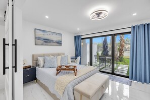 A modern bedroom with a bed, bedside table, and a view of the outdoors. - Stunning Designer Studio with Luxury Finishes (Deerfield Beach)
