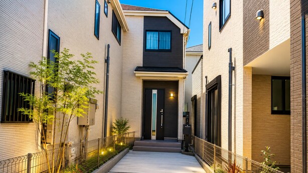 A narrow alleyway between two modern buildings with a door at the end. - 2-Min Walk to Koya Station | Brand-New 4BR Private House | Free Parking & Wi-Fi (足立区)
