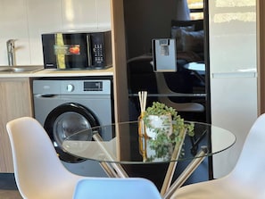 Una cocina compacta con lavadora, microondas y refrigerador.