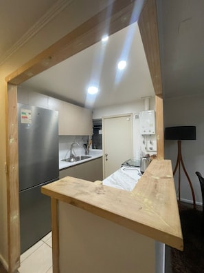 Eine Küche mit einem Edelstahl-Kühlschrank, einer Spüle und einer Holzarbeitsplatte.
