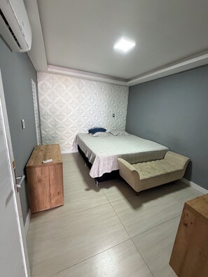 A bedroom with a bed, a bedside table, a wardrobe, and a ceiling light. - Vrbo Property (Belém)
