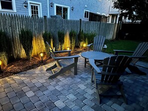 Eine Terrasse im Freien mit Holzzaun, Tisch und zwei Stühlen.