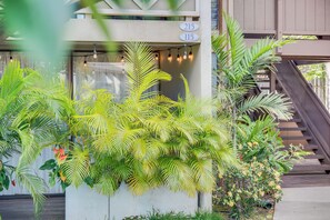 A building entrance with a staircase, potted plants, and a number sign. - 2BR Kihei Condo | Walk to Sugar Beach, Pool, Hot Tub & 2 King Beds (Kihei)
