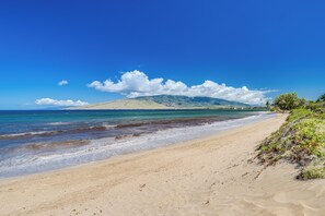 A beach with clear skies, a sandy shore, and distant mountains. - 2BR Kihei Condo | Walk to Sugar Beach, Pool, Hot Tub & 2 King Beds (Kihei)