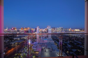 A cityscape view from a high-rise building at dusk, featuring prominent buildings and a casino area.