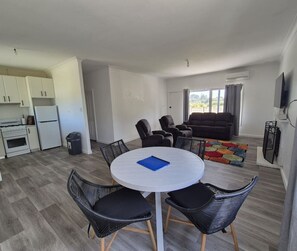 Un appartement moderne comprenant un coin repas, une cuisine et un espace de vie.