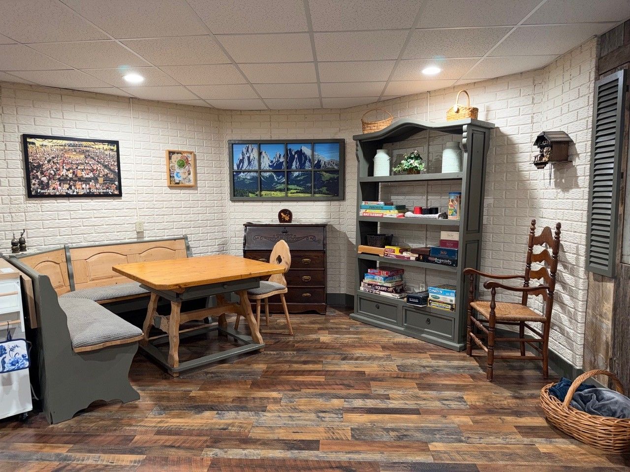 Una habitación con una mesa de madera, un banco, una estantería y una chimenea.