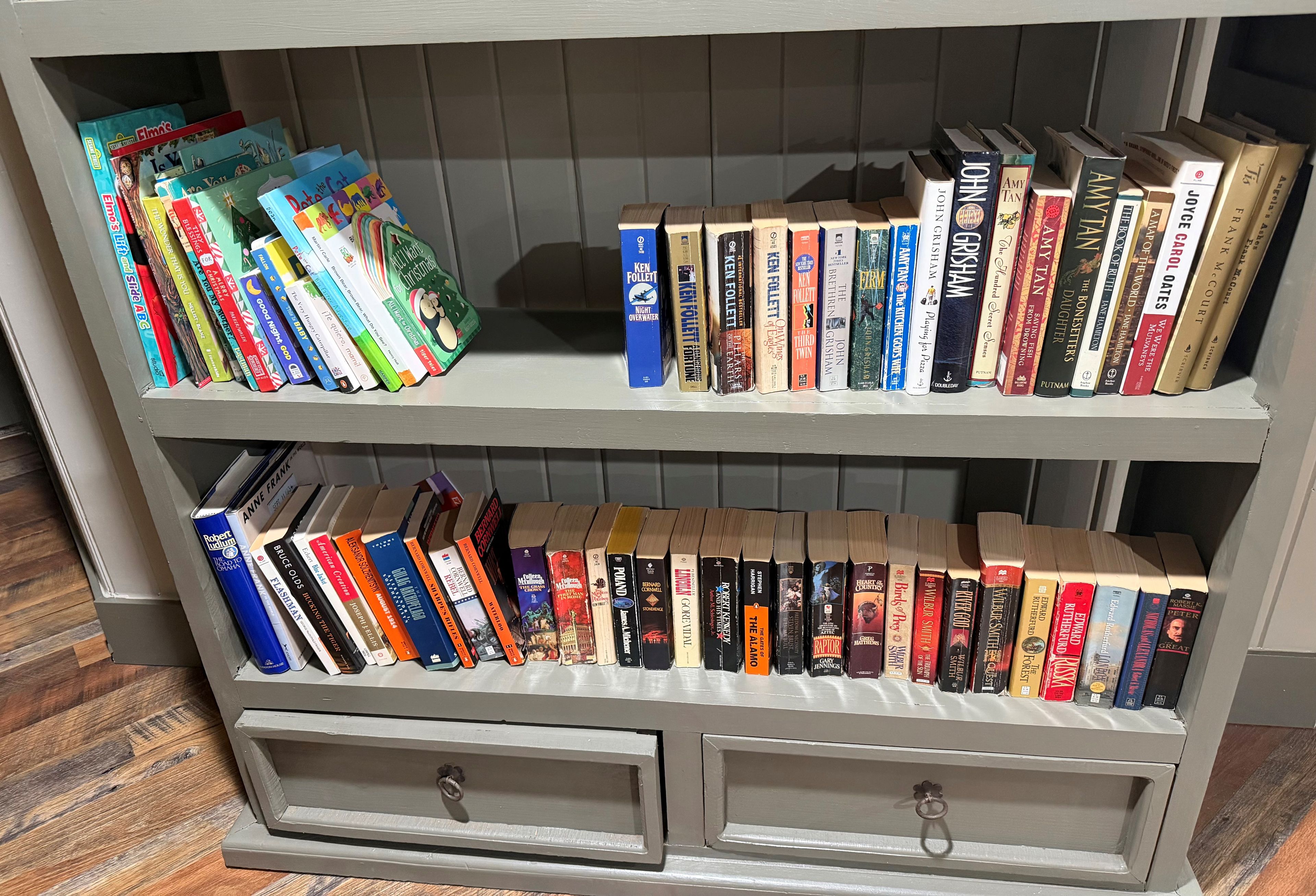 A bookshelf with a variety of books, including children's books and novels.