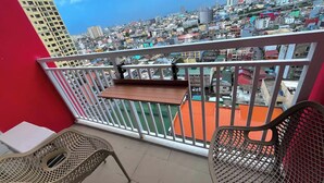 Un balcón con vistas a la ciudad, una mesa y dos sillas.