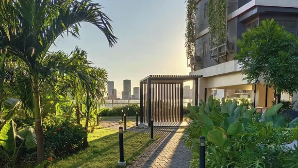 Un camino pavimentado que lleva a un edificio moderno con vistas al horizonte de la ciudad.