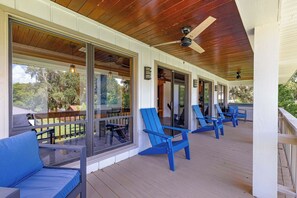 Een overdekt terras met blauwe stoelen en een houten plafond.
