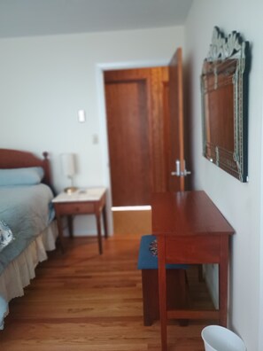 Ein Schlafzimmer mit Bett, Nachttisch und einem Holzkontor.