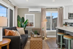 Eine moderne Küche mit Essbereich, einer Couch und einem großen Fenster.
