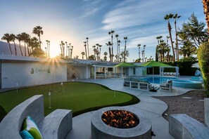 Ein Golfplatz mit Putting Green, Schwimmbecken und Feuerstelle.