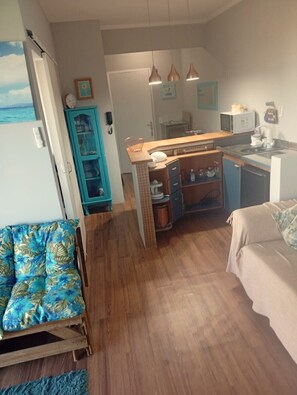 A compact living space with a kitchenette, a dining area, and a small seating area. - Beachfront property with two oceanfront balconies (São Vicente)