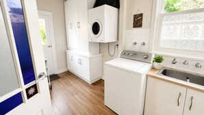 A laundry area with a washing machine, dryer, and sink. - Crofton House @ Port of Echuca - Heritage (Echuca)