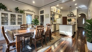 A spacious kitchen with wooden cabinets, a dining area with a large table and chairs, and a central island.