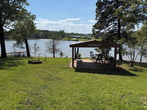 Ein Pavillon mit Sitzgelegenheit im Freien, einem Steg und Seeblick.
