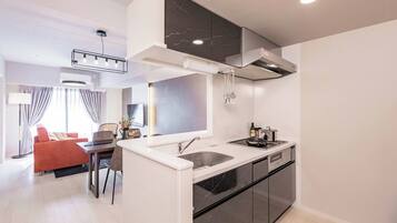 A modern kitchen with a built-in stove, sink, and black cabinets.