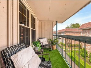A balcony with a sofa, two chairs, and potted plants. - World Cup Ready 2BR Near NRG Stadium Skip the Parking (Houston)