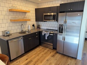 Cocina moderna equipada con lavavajillas, microondas, horno y refrigerador.