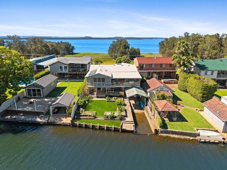 A waterfront property with multiple houses, a dock, and a clear view of the water.. WaterFront With Panoramic Views: Sunrise and Sunset