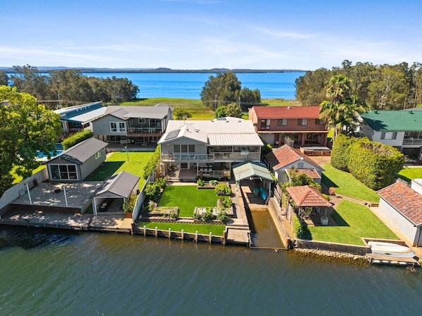 A waterfront property with multiple houses, a dock, and a clear view of the water.