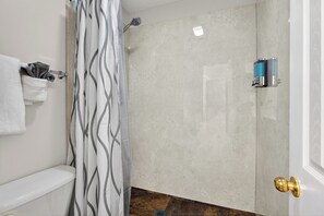 A bathroom with a shower, toilet, towel rack, and a door with a golden handle. - Savannah Oasis: Huge 6BR Home w/Arcade & King Beds
Sleep 12, 9 beds, 6 BR, 3 BA (Pooler)