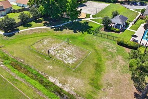 An aerial view of a residential area with a well-maintained lawn, a fenced sports court, and a gazebo. - Savannah Oasis: Huge 6BR Home w/Arcade & King Beds
Sleep 12, 9 beds, 6 BR, 3 BA (Pooler)