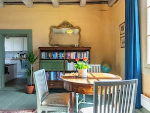 A dining area with a round table, chairs, a bookshelf, a mirror, and a globe. - Vanhakylä gård väentupa by Interhome (Sastamala)