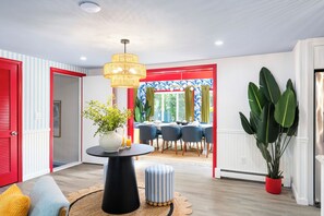 A dining area with a round table, chairs, and a hanging light fixture. - Pool+HotTub+Pickleball+Game+Movie+PlayRoom+PetsOK (Barnstable)