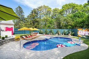 A backyard with a swimming pool, sun loungers, and a mural. - Pool+HotTub+Pickleball+Game+Movie+PlayRoom+PetsOK (Barnstable)