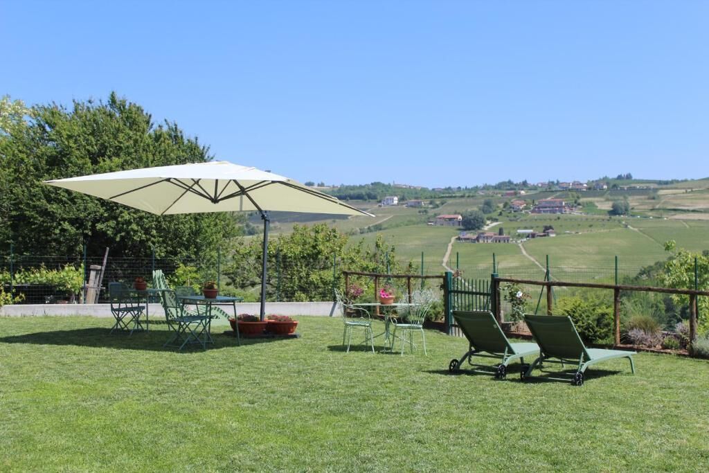 Un patio con una mesa, sillas y una sombrilla.
