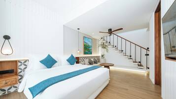 Un dormitorio moderno con una cama grande, una mesita de noche de madera, una mesa redonda y una escalera que sube a un nivel superior.