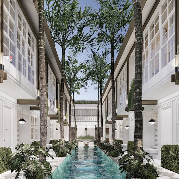 A pool with a clear blue water surface, surrounded by white walls and tall palm trees.