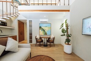 Un intérieur moderne avec un escalier, un coin repas, un canapé et une plante en pot.
