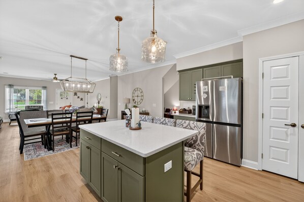 A spacious kitchen with a central island, modern appliances, and pendant lighting.
