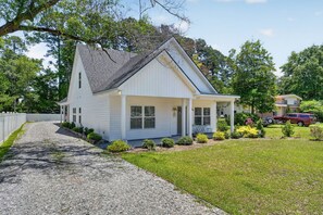 A single-story house with a front porch, a gravel driveway, and a well-maintained lawn.