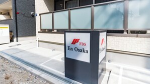 En byggnad med en skylt som visar texten ”FDS En Osaka” och en modern design med en fasad av kakel och stora fönster.