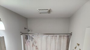 Une salle de bain équipée d’un rideau de douche orné d’un motif de libellule, de toilettes, d’un lavabo et d’une baignoire.