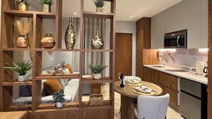 Eine moderne Küche mit Holzwand, integrierten Geräten und einem Essbereich mit rundem Tisch und Stühlen.