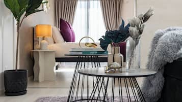 A modern living room with a round table, a sofa, a lamp, and decorative items.