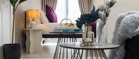 Una sala de estar moderna con una mesa redonda, un sofá, una lámpara y elementos decorativos.