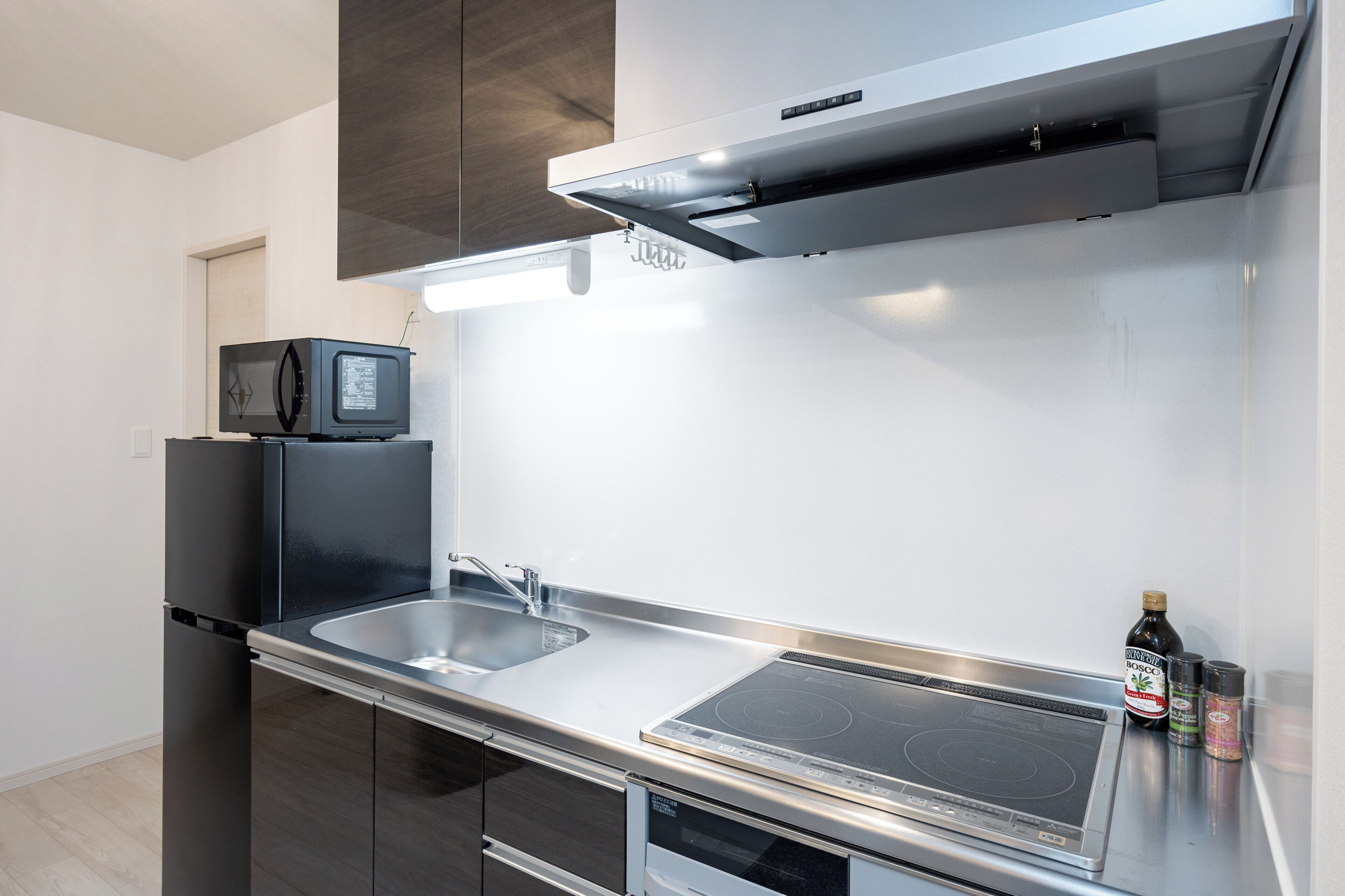 A modern kitchen with a microwave, sink, stove, and cabinets.